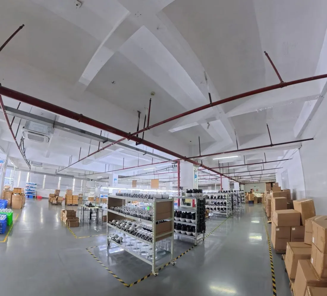 Camera housings and components staged on racks in the factory